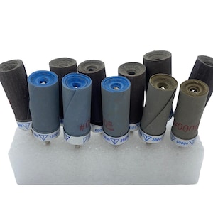 May include: A set of 10 sanding drums for a rotary tool. The drums are made of sandpaper and are different grit sizes: 600, 800, 1500, 2500, 3000, and 5000 grit.
