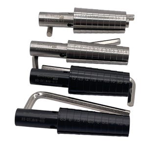 May include: Four ring sizing tools. Two are silver-colored, labeled "SSMAN" with size markings. The other two are black, labeled "RS-DELMAN" with size markings. Each tool has a handle for adjustment. The tools are used for measuring ring sizes.