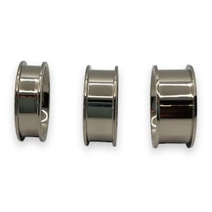 May include: Three silver metal rings of different sizes. The rings are smooth and have a polished finish.