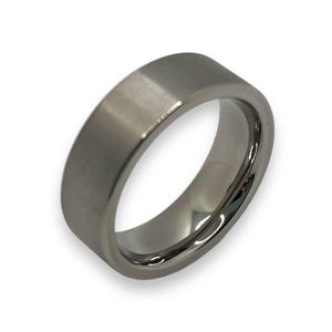 May include: A brushed silver wedding band with a beveled edge.