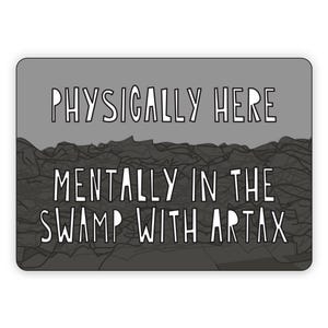 Peut inclure: Un autocollant rectangulaire avec un fond gris et du texte blanc. Le texte se lit comme suit : "PHYSICALLY HERE MENTALLY IN THE SWAMP WITH ARTAX". La moitié inférieure de l'autocollant présente une illustration sombre de type marécage.