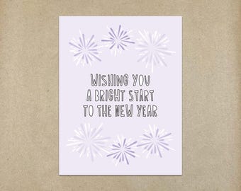 Peut inclure: Une carte de vœux de Nouvel An violette et blanche avec des feux d'artifice et le texte "Wishing you a bright start to the new year."