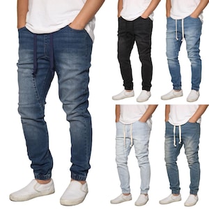 May include: Five pairs of denim jogger pants in various shades of blue and black. Each pair features a drawstring waist, elastic cuffs, and pockets. The pants are shown with white slip-on shoes.