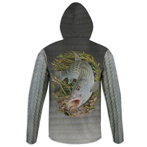 May include: A long-sleeve hooded shirt featuring a gray and black gradient background. The back displays a detailed graphic of a striped fish swimming through green seaweed with its mouth open, revealing a small bait or lure inside the mouth.