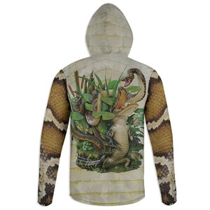 May include: A long-sleeved hoodie with a beige background and a graphic print of an alligator, snakes, and other wildlife. The sleeves are printed with a snake skin pattern.