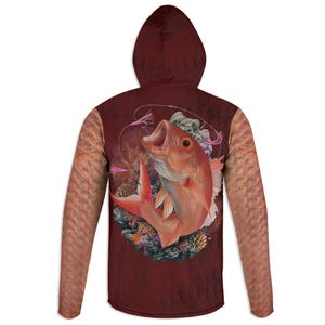 May include: Maroon hoodie featuring a detailed illustration of a red snapper fish with an open mouth, surrounded by coral and fishing tackle. The sleeves have a textured, skin-like pattern. The hood is a solid maroon color.