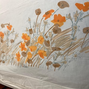 Puede incluir: Tela blanca con un estampado floral repetido en naranja, marrón y verde. El diseño presenta flores estilizadas, hojas y elementos similares a la hierba. La estética general recuerda a una ilustración botánica vintage.