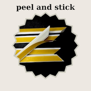 May include: White flexible molding strips with a yellow adhesive backing and a partially peeled brown protective liner. The text peel and stick is displayed above the strips, which are arranged against a black background inside a starburst shape.