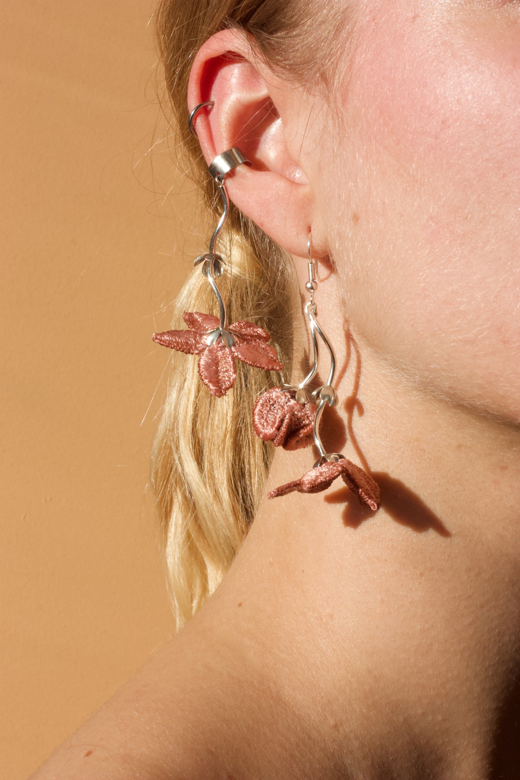 つまむ手とフラワータッセルのピアス （タッセルの簡単寝ぐせ直し術を  