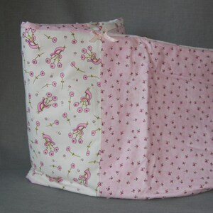 May include: A pink and white pillow with a floral pattern. The pillow is made of two different fabrics, one with a small pink floral pattern and the other with a larger white floral pattern with pink flowers.