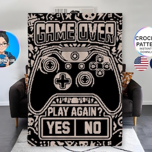 Peut inclure: Une couverture au crochet rectangulaire présentant un motif pixel art noir et beige représentant une manette de jeu vidéo. Le texte GAME OVER est en haut, avec PLAY AGAIN? et les options YES et NO affichées en bas du graphique.