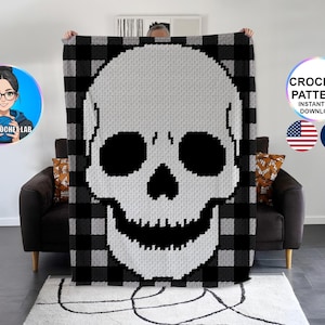 Könnte beinhalten: Eine große Häkeldecke mit einem Totenkopf-Design in Schwarz und Weiß. Der Totenkopf ist auf einem grau-schwarzen Büffelleder-Hintergrund zentriert. Die Worte "CROCHET PATTERN INSTANT PDF DOWNLOAD" stehen in einem Kreis.