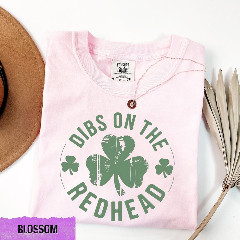 a pink shirt with a green shamrock on it