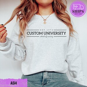 a woman wearing a sweatshirt that says custom university