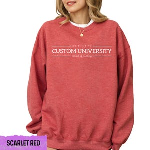 a woman wearing a red sweatshirt that says custom university