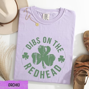 a t - shirt that says dubs on the redhead next to a pair of