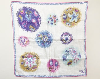 May include: A white cotton handkerchief with a pink, blue, and gold paisley pattern. The handkerchief has a pink border.