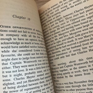 Op de afbeelding: Open boek met tekst uit een roman. De linkerpagina leest "Hoofdstuk 10" en "ANDERE KANSEN...". De rechterpagina heeft tekst over een personage genaamd Hayter. De pagina's zijn verouderd met een gelige tint.