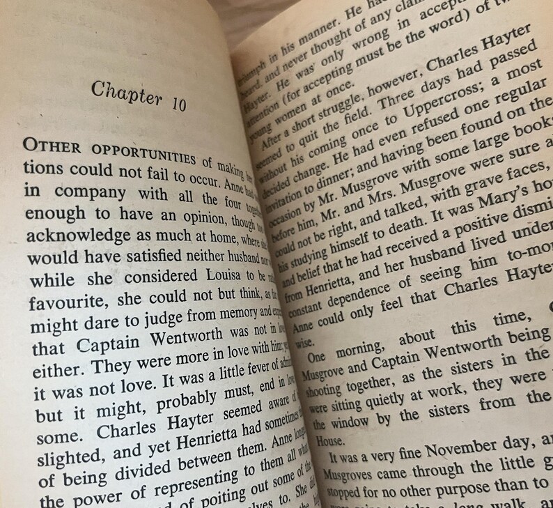Op de afbeelding: Open boek met tekst uit een roman. De linkerpagina leest "Hoofdstuk 10" en "ANDERE KANSEN...". De rechterpagina heeft tekst over een personage genaamd Hayter. De pagina's zijn verouderd met een gelige tint.