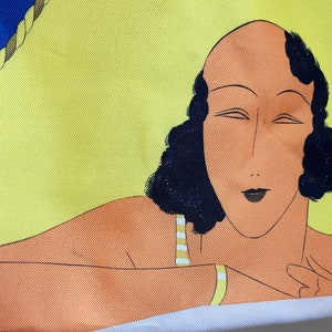 May include: A yellow and orange tote bag with a colorful illustration of a woman with black hair and a striped swimsuit.
