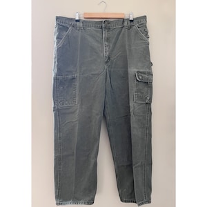 Może przedstawiać: Zielone spodnie cargo z wieloma kieszeniami.