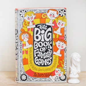 May include: A vintage book cover with a colorful illustration of a game board and smiling faces. The title is "The Big Book of Family Games" by Jerome Meyer.