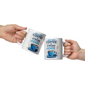 Puede incluir: Dos tazas de café blancas con el texto "May Your Coffee Be Strong & Your Faith Stronger". Cada taza presenta un diseño de taza y platillo de café azul. Las tazas se sostienen sobre un fondo blanco.