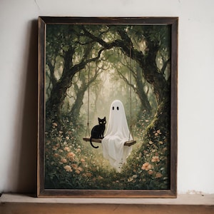 May include: A framed wall art print depicting a white ghost and a black cat sitting together on a wooden swing suspended from tree branches in a forest filled with small pink flowers and lush green foliage under a soft, diffused light.