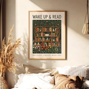 May include: A framed print featuring the words "WAKE UP & READ" above a detailed illustration of a bookshelf. The bookshelf is filled with books, plants, and flowers. The text "NATIONAL LIBRARY WEEK 1951" is at the bottom.