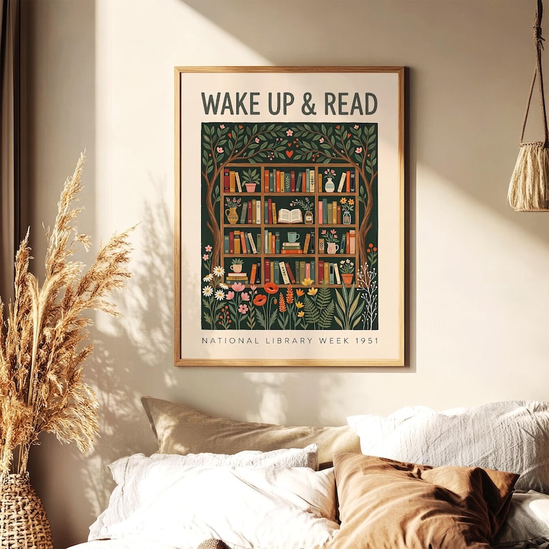 May include: A framed print featuring the words "WAKE UP & READ" above a detailed illustration of a bookshelf. The bookshelf is filled with books, plants, and flowers. The text "NATIONAL LIBRARY WEEK 1951" is at the bottom.