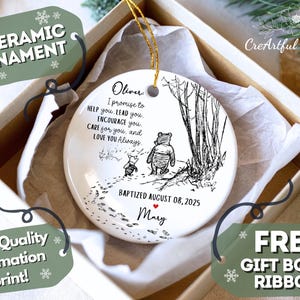 May include: A 7.6 cm ceramic ornament with a black and white illustration of Winnie the Pooh and Piglet. The ornament has the text "I promise to help you..." and is presented in a gift box with a ribbon.