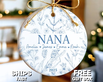 May include: White ceramic ornament with blue floral design and the word "NANA" in blue. Below the word "NANA" are the names Amelia, James, Emma, and Noah. The year 2025 is printed on the ornament. A gold string is attached for hanging.