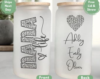 May include: A frosted glass tumbler with a lid and straw. The front of the tumbler has the word "NANA" in black with a leopard print pattern. The back of the tumbler has a heart with a leopard print pattern and the names "Ashley, Emily, Oliver" written in black.