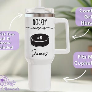 May include: White insulated tumbler with a handle, featuring the text "HOCKEY mama" and a hockey puck graphic. Includes a twist-top lid and straw. The name "James" is printed below the puck. The tumbler fits most cup holders.