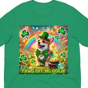 Könnte beinhalten: Grünes T-Shirt mit einem St. Patrick's Day-Design. Die Grafik zeigt einen Corgi mit grünem Hut und Fliege, einen Regenbogen, Kleeblätter und einen Goldtopf. Der Text auf der Grafik lautet "PAWS OFF ME GOLD!"