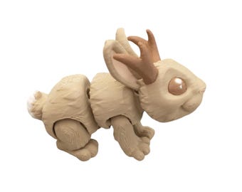 May include: A beige articulated toy rabbit with brown antlers. The rabbit has a white tail and brown eyes.