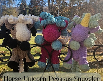 May include: Three crocheted stuffed animals: a brown and white horse, a pink unicorn with blue mane and tail, and a purple pegasus with yellow horn and green mane and tail. The animals are hanging on a black metal fence. The text "Horse/Unicorn/Pegasus Snuggler CROCHET PATTERN" is at the bottom of the image.