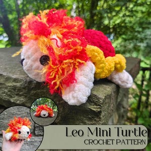 Puede incluir: Una tortuga Leo Mini hecha a ganchillo, con cuerpo blanco, caparazón rojo y amarillo, y una melena esponjosa en tonos rojos, naranjas y amarillos. El texto "Leo Mini Turtle CROCHET PATTERN" es visible, indicando un patrón de ganchillo.