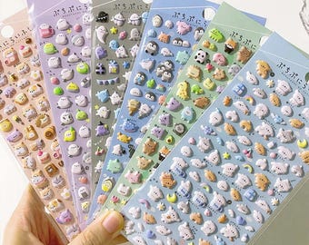 以下が含まれることがあります： 幽霊、ペンギン、動物など、さまざまなかわいい漫画のキャラクターが描かれた、カラフルなふっくらしたステッカーの6枚セット。ステッカーは透明なビニール袋に入っていて、日本語でラベル付けされています。