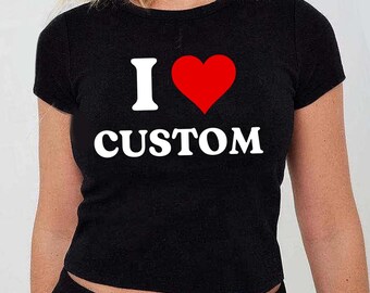 May include: Black crop top with the text "I ♥ CUSTOM" in white and a red heart. The shirt is a crew neck style.