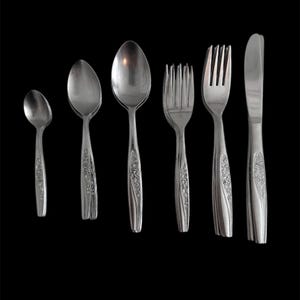 May include: A set of six silver-toned cutlery pieces, including a butter knife, two forks, and three spoons. The handles of the cutlery are decorated with a floral pattern.