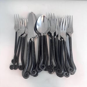 May include: A set of cutlery featuring forks, spoons, and a knife. The utensils have dark, textured handles with a decorative spiral design at the base. The spoon and fork heads are shiny silver.