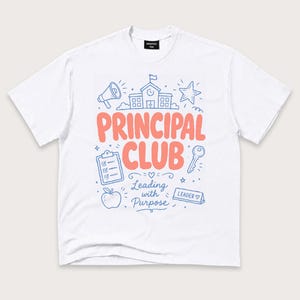 May include: A white short-sleeve t-shirt featuring a graphic print in coral and blue. The design includes the text "PRINCIPAL CLUB" and "Leading with Purpose," alongside illustrations of a school building, megaphone, star, clipboard, key, apple, and a "LEADER" sign.