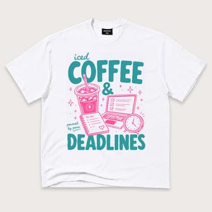 May include: A white short-sleeve t-shirt featuring a graphic print in teal and pink. The design includes the text "iced COFFEE & DEADLINES" and "powered by panic," alongside illustrations of an iced coffee, a laptop, a to-do list, and a clock.