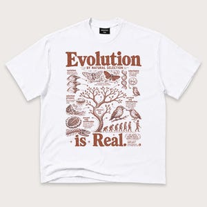 May include: A white short-sleeve t-shirt featuring a brown graphic print on the front. The design displays a central tree surrounded by biological illustrations, including moths, birds, and human evolution, with the text "Evolution BY NATURAL SELECTION is Real."