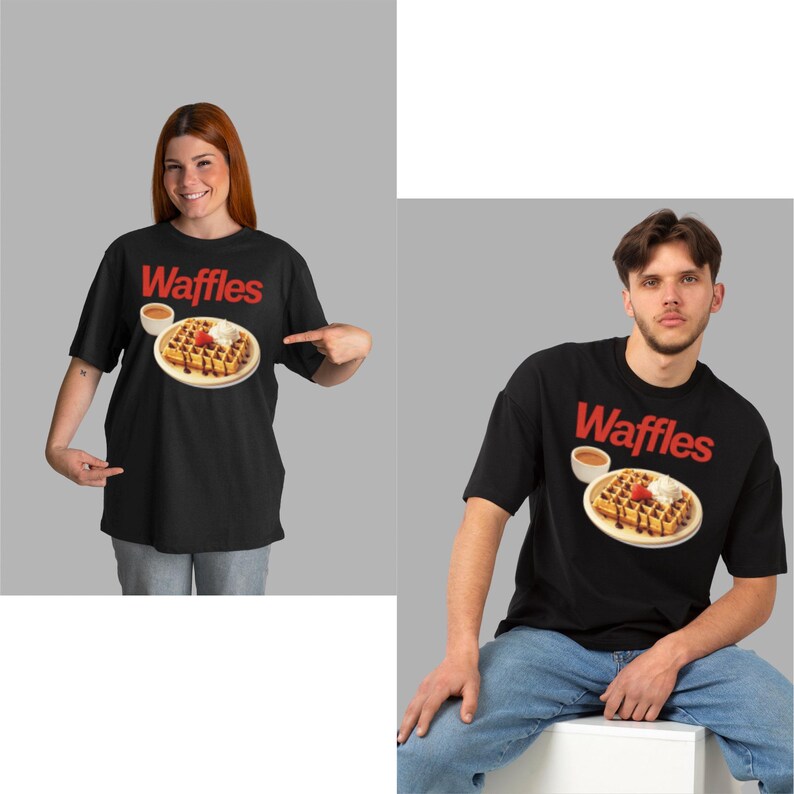 以下が含まれることがあります： 赤い「Waffles」の文字が入った黒いTシャツ。シロップ、ホイップクリーム、イチゴを添えたワッフルのグラフィックが特徴です。2人がTシャツを着ています。