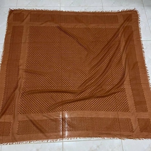 May include: A brown patterned square scarf with a fringed edge.
