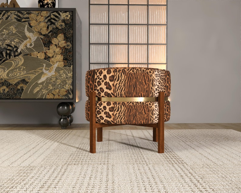 a leopard print armchair placed on a white rug in a room with a large window and a decorative cabinet.
