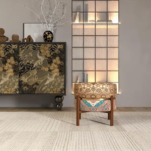 a modern living room with a black and gold cabinet, a patterned armchair, and a glass-paneled divider.