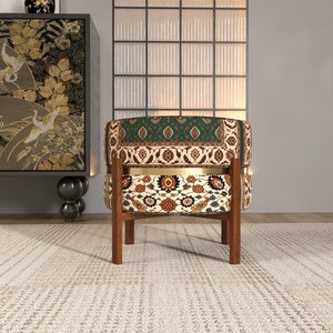 a colorful, patterned chair with a wooden frame, placed on a white rug in a minimalist setting.